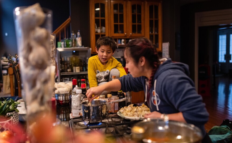 Thu drops in dumplings for Lunar New Year celebrations as Hayle checks on the pot of boiling water on Jan. 26, 2020.