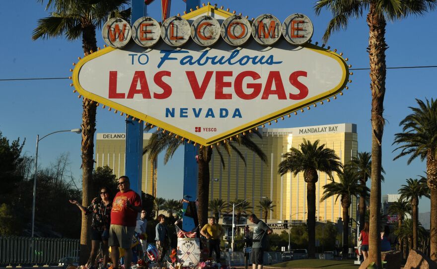 Tourists pose for photos in front of the city's welcome sign near Mandalay Bay, which doubled as a memorial site after the shooting last October. On Wednesday, Las Vegas police released more than 1,000 pages of witness statements giving a deeper look into the moments leading up to the massacre.