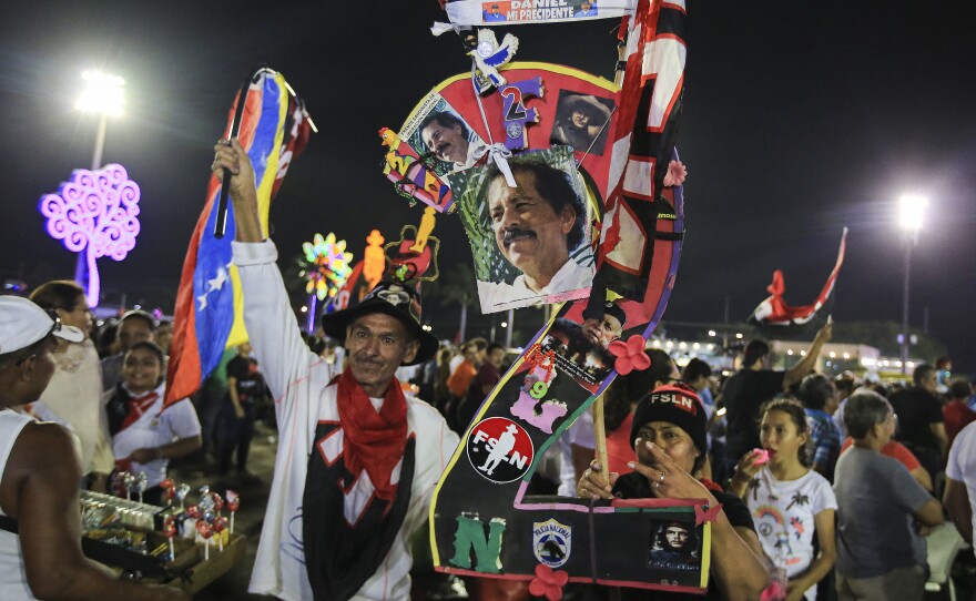 Supporters hold pictures of Nicaraguan President Daniel Ortega while taking part in an event at the Juan Pablo II square on the eve of the 44th anniversary of the Nicaraguan Revolution in Managua on July 18, 2023.