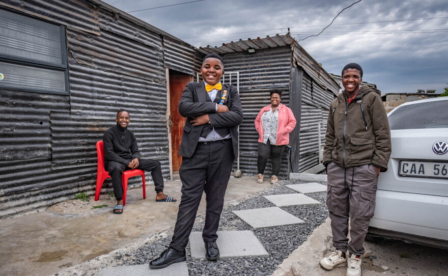 Aspiring magician Lubelo Mthenjana is clearly the family star as they stand outside their home in the Khayelitsha neighborhood of Cape Town.