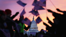 People wave American flags as people gather near the U.S. Capitol building on th