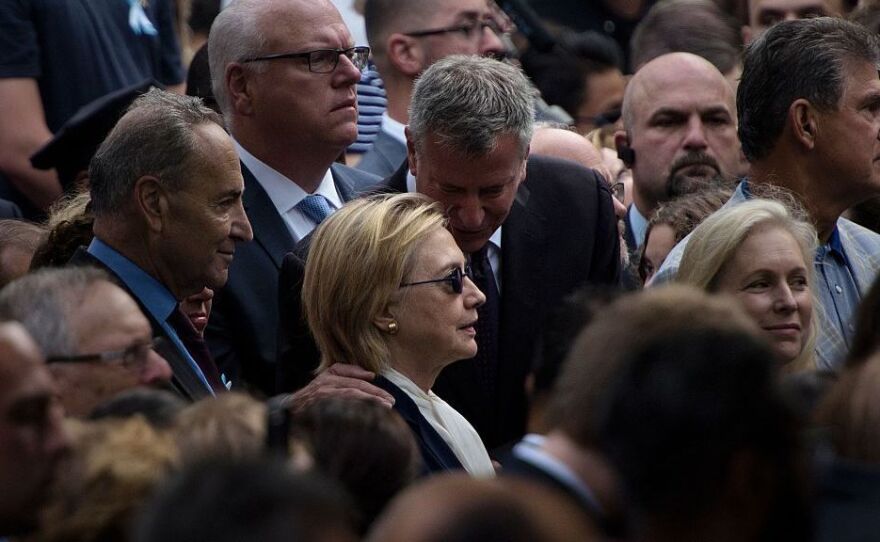 New York City Mayor Bill de Blasio speaks to Democratic presidential nominee Hillary Clinton during a memorial service at the National September 11 Memorial and Museum in New York.