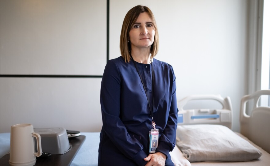 Kristin Grunewaldt, a registered nurse clinical coordinator at the Minnesota Correctional Facility in Oak Park Heights, sits on a bed in the prison's Transitional Care Unit. This unit is for elderly and sick prisoners who need 24-hour care.