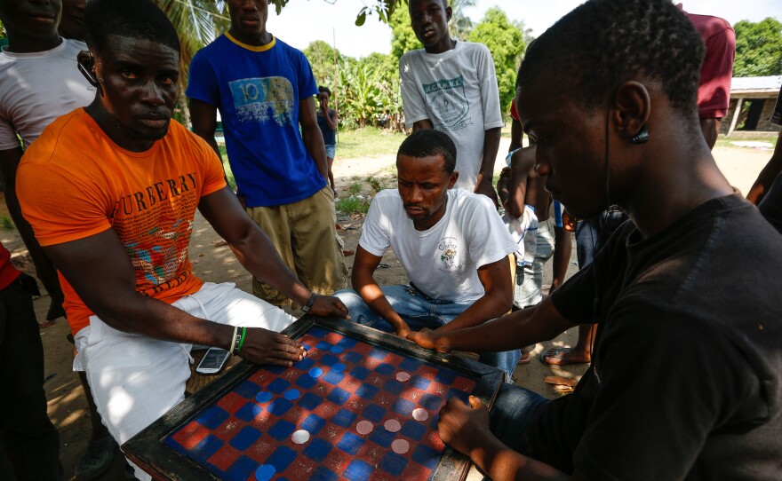 Check-Up looks like a cross between checkers and the British game draughts. There's a square checkerboard, black and red pieces, diagonal jumps and an unusual West African addition — the flicking of fingers on board squares.