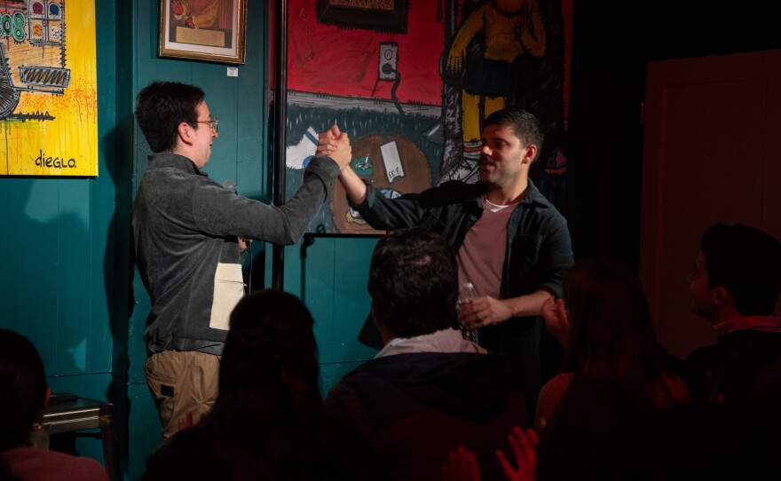 Fellow performer Daniel Castañeda, left, welcomes Colina to the stage.