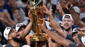 The New York Knicks celebrate with the Larry O'Brien Championship Trophy after defeating the San Antonio Spurs in Game 5 of the NBA Finals basketball series, Saturday, June 13, 2026, in San Antonio. (AP Photo/Darren Abate)