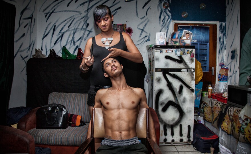 Chedino cuts the hair of a friend at Miss Whall's house in Ravensmead, Cape Town, South Africa, in 2014. Aside from her job in a call center, Chedino worked as a hairdresser to earn some extra money. As a teenager, Chedino was often employed as her family's hairstylist and make-up artist. "Whenever anyone had any fashion questions or needed styling, they would ask me."