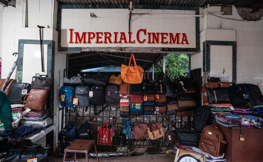 Mumbai is infamous for its street hawkers, and a lot of goods are sold on the streets; clothes, bags, shoes, office supplies, household items, electronics, etc. A seller has set up shop outside one of Imperial Cinema's bolted gates.