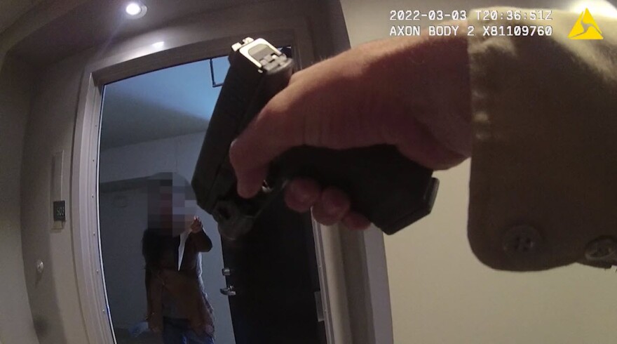 In this still from SDPD's critical incident video, a SDPD officer points a gun at Yan Li in the Little Italy neighborhood of San Diego, Calif. March 3, 2022.