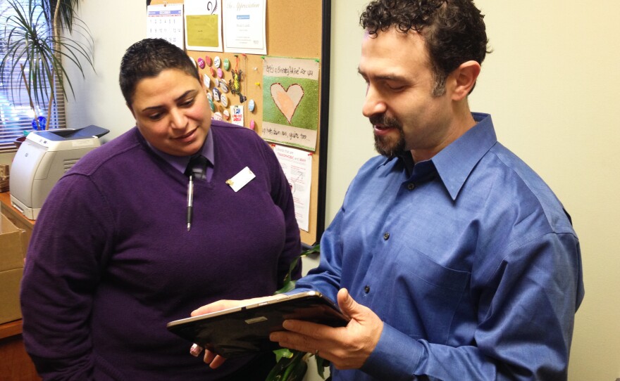 Clinic director Priscilla Castillo looks at a tablet with a new electronic system that will attempt to cut costs at the Planned Parenthood in Concord.