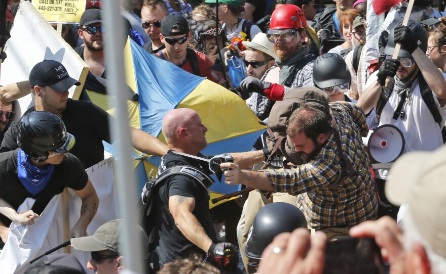 In this Aug. 12, 2017 file photo, white nationalist demonstrators clash with counter demonstrators at the entrance to Lee Park in Charlottesville, Va.