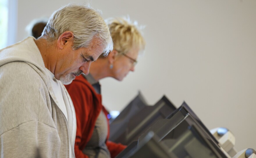 People cast their ballots on electronic voting machines at the Provo Recreation Center on Oct. 25, the first day of early voting in Provo, Utah.