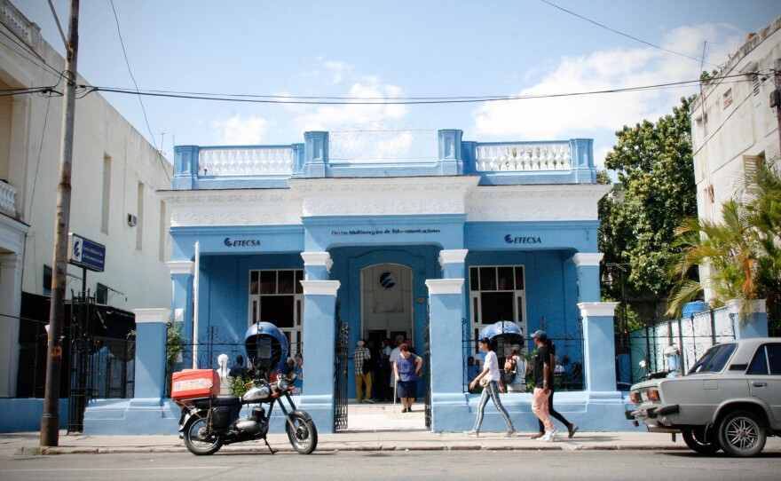 Cubans wait in line to use four computers connected to the Internet at the offices of Cuba's state-owned telecom monopoly.