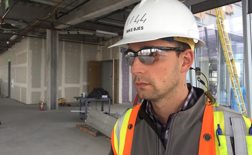 Construction manager Michael Bjes says this building's all-glass exterior has a protective coating, and an internal layer of argon gas, to reduce heat transfer and the use of air conditioning.