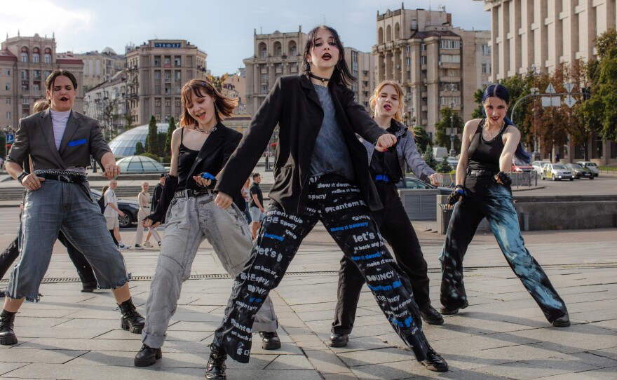 Phantom Blue K-pop cover dance crew performs and records in Maidan Square, surrounded by friends and family who come to support, help with hair and makeup, and cheer them on.