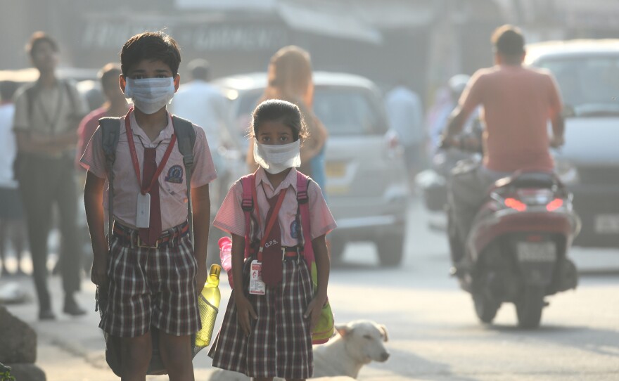 Students cover their faces with masks to protect themselves from air pollution in Delhi.