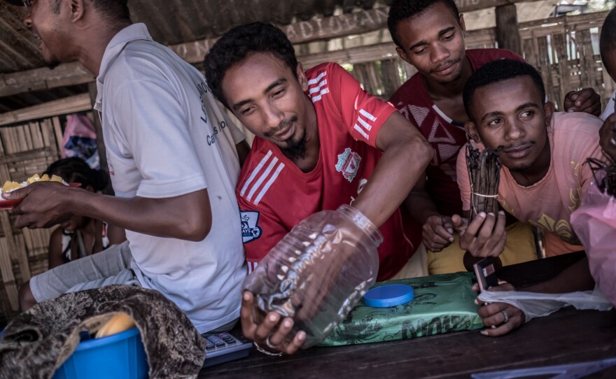 Street trader Randria Albert Francois with colleagues at his stall in Antalaha, Madagascar.