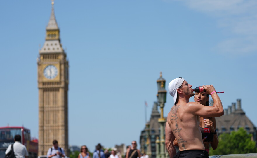 A man drinks on Westminster Bridge in London, as a heat wave is predicted Tuesday, June 23, 2026.