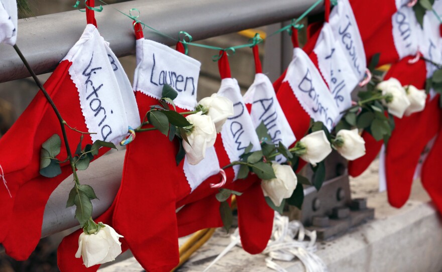 Christmas stockings with the names of shooting victims hang from a railing in the Sandy Hook village of Newtown, Conn.
