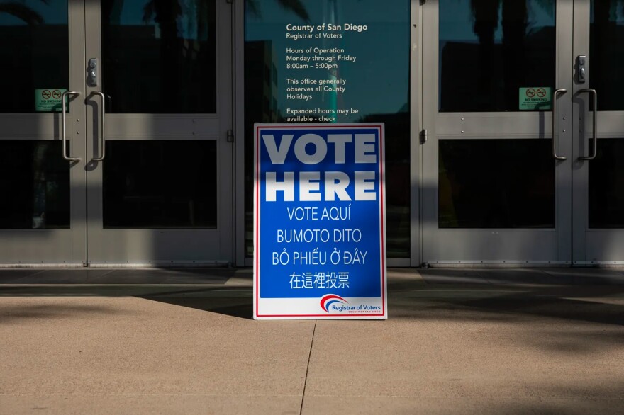 A sign outside the San Diego Registrar of Voters reads “vote here” in several languages. Counties would have to translate more ballots and help more immigrant citizens vote under a new bill.