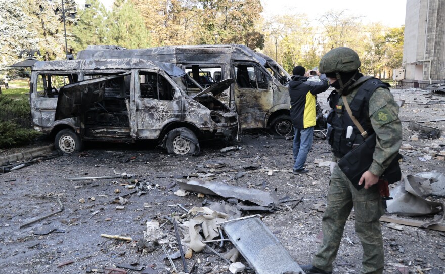 Investigators inspect a site after shelling near an administrative building in Donetsk on Sunday.