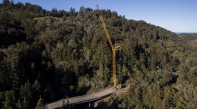 A crane sits on Highway 1 south of the Pfeiffer Canyon Bridge in Big Sur, Calif. Residents are adjusting after the bridge on the Central California coast crumbled last month in heavy rains, splitting the touristy Big Sur area in two, March 13, 2017. 