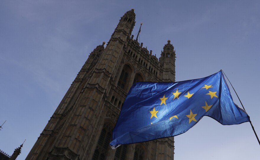 A European Union flag flies Monday outside the Parliament building in London. The multinational bloc has agreed to grant the U.K. another Brexit delay, bumping the deadline to the end of January.