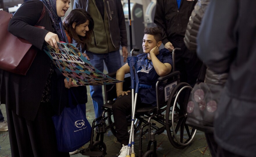 Mustafa and his family meet friends at the airport in Portland. Mustafa had been hoping for a new prosthetic leg, but his injuries are so severe that he won't get one on this visit.