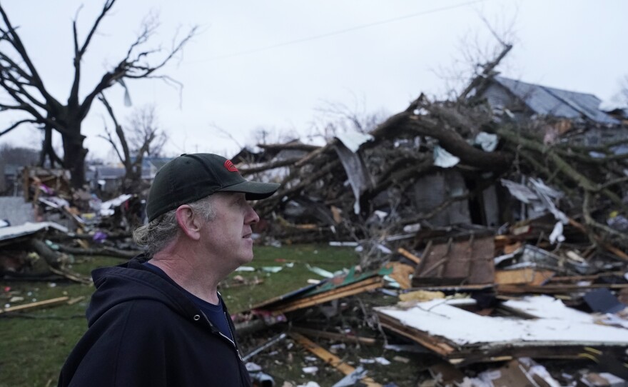 Greg McDougle walks near debris on Friday, following a severe storm in Lakeview, Ohio.