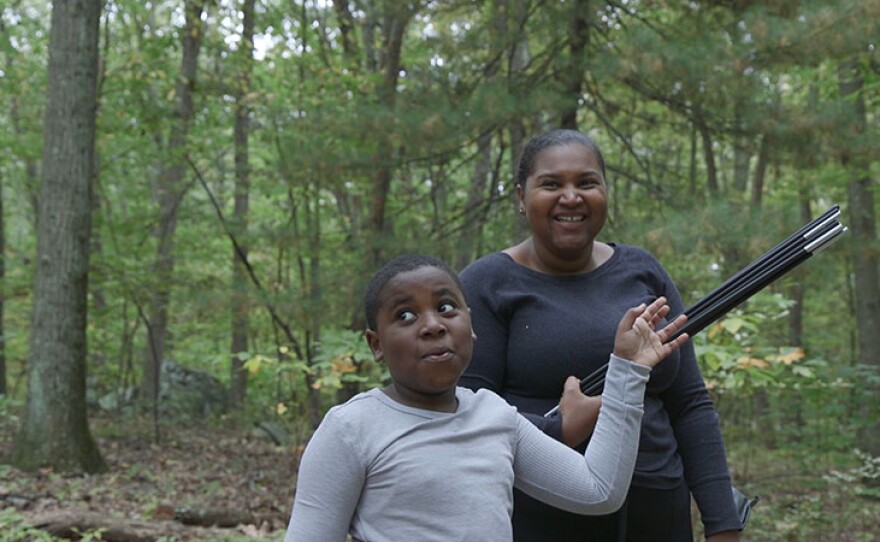 Dasan and his mom building a tent during a scout camping trip.