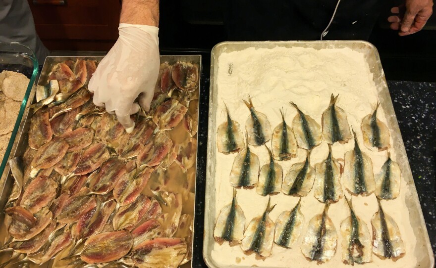 Sobeh flours sardines caught off the Gaza coast ahead of frying them. Citing security, Israel's navy enforces restrictions on how far into the Mediterranean Gaza fishermen can work, which impacts their livelihood and the potential for seafood exports. Last month, part of the zone was extended from 6 nautical miles to 9 for the first time in a decade.