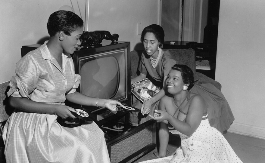 Ernestine Hooks handing record to Martell LaGrone-Girhan, late 1940s- early 1950s