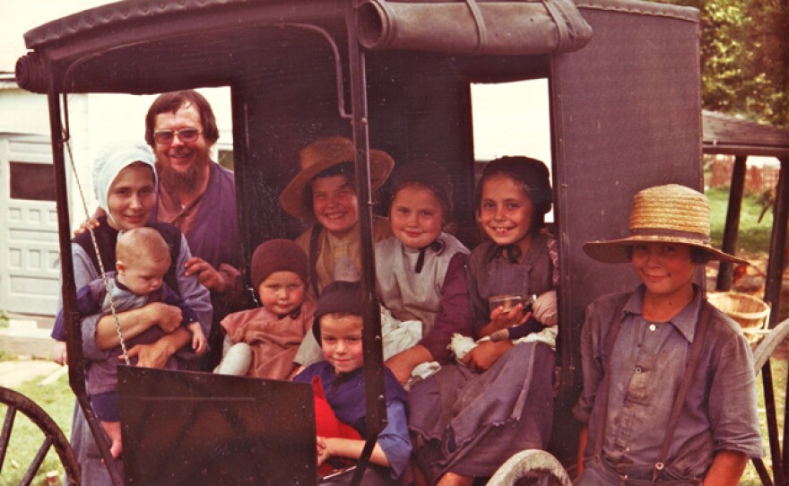 Edwards family photo taken in August 1977. Although the family is dressed in traditional Amish clothing, this was taken a few years before they became members of the Amish church. Jan Edwards is on the left wearing a white cap; Paul Edwards is standing to the right of the buggy.