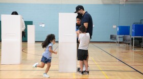 Hector and Maribel Hernandez fill out ballots with their three children at the Mid-City Gym in City Heights, Nov. 3, 2020.