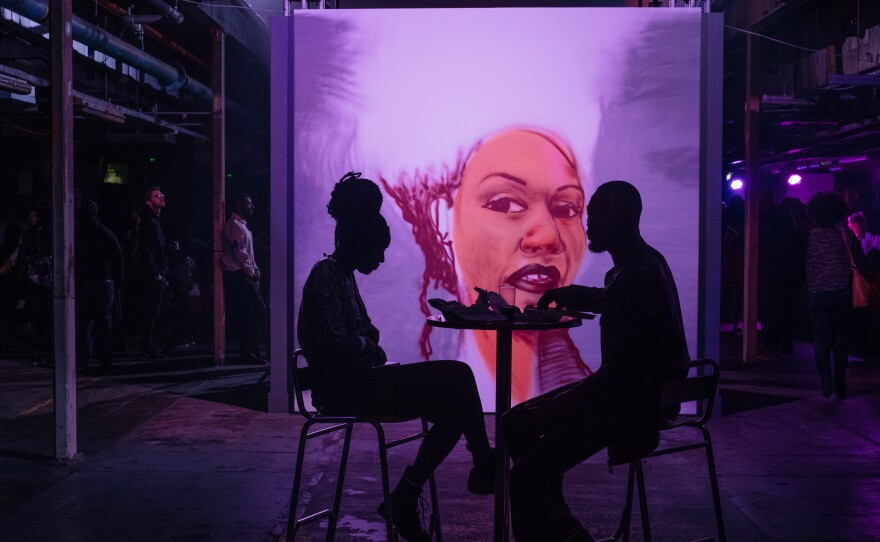 A mural illuminates an intimately lit lounge area at the Afropunk London festival in July 2017.