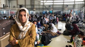 Afghan evacuees wait for the next flight to the U.S. in a fenced-in enclosure in a hangar at Ramstein Air Base in Germany. More than 25,000 Afghans have traveled through Ramstein to get to the United States.