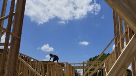 Workers work on the roofing structure of new home under construction, Tuesday, July 15, 2025, in Richardson, Texas.