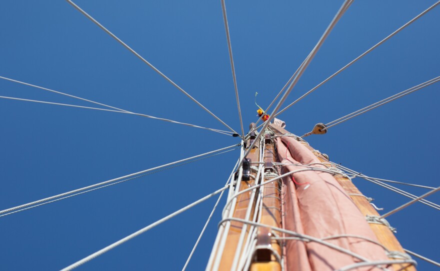 The mast must come down in the next part of the journey to get past the bridges on the Potomac River on the way to the Washington, D.C., stop. The lei at the very top is color coded; traditionally each captain had his own color so the boats could recognize who was on it from afar.