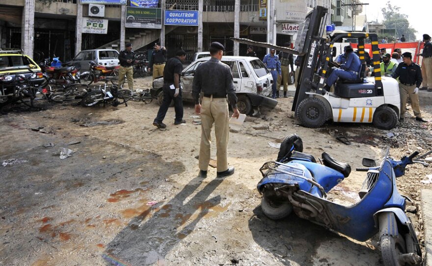 Pakistani policemen secure the site of a suicide bomber's blast in Rawalpindi on Monday. A suicide bomber on a motorbike ripped through a line of people outside a bank in the garrison town outside Islamabad, the capital, killing at least 35 people and wounding scores more.