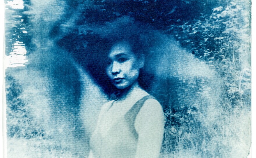 Self portrait, Rock Creek Park, Washington, D.C., May 2022. The texture and color of the cyanotype looks similar to a shanku, an everyday outfit worn by the Hakka ethnic group in China of which Shuran Huang proudly belongs. Worn by men and women of all ages, a shanku is usually blue and black, with little ornamentation.