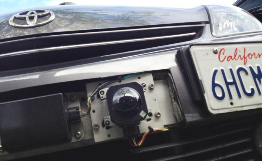 A car camera attached to the front bumper of Google's driverless car.