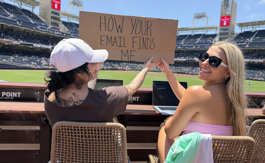 Fans hold a sign reading "How your email finds me" at the Padres game