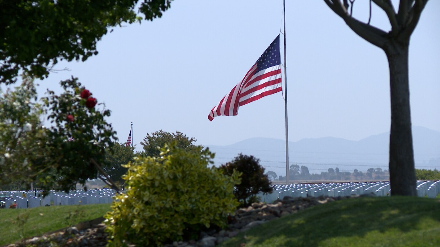 A large, single flag hangs at half staff at Miramar National Cemetery on July 3, 2025.