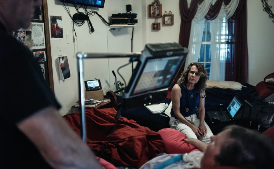 Miller listens to Budd and Terri Wyman. Terri, 55, can only communicate with her eyes using a speech-generating device.