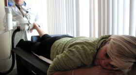 Orthopedic surgeon George  Theodore of Massachusetts  General Hospital delivers shock-wave therapy to  Tara Cassidy Driscoll's painful left foot.