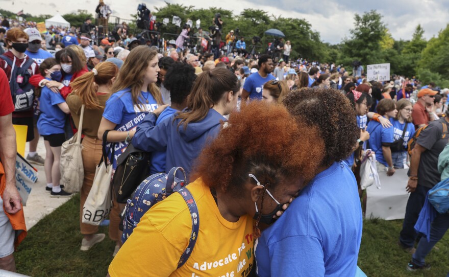 Demonstrators console each other after a counter-protester jumped a barricade in an attempt to disrupt a March for Our Lives rally against gun violence.