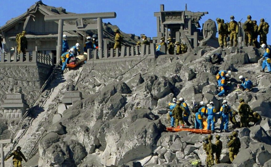 A photo taken from a Kyodo News helicopter shows Japan's Self-Defense Forces personnel rescuing climbers who were in critical condition near the top of Mt. Ontake Monday, before rescue operations were suspended.