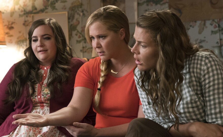 Aidy Bryant (left) and Busy Phillips play best friends to  Schumer's Renee in the almost-reverse-makeover movie.