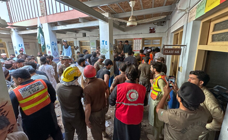 Rescue workers and volunteers take part in the rescue operation at the site of a roof collapse at a private school, in Peshawar, Pakistan, Thursday, Oct. 15, 2026.