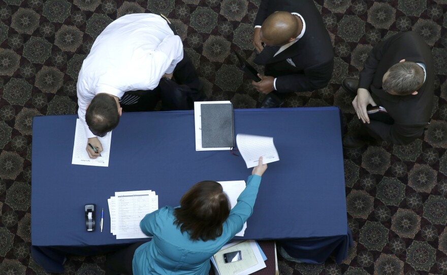 Job seekers sign in before meeting prospective employers during a career fair at a hotel in Dallas last month.